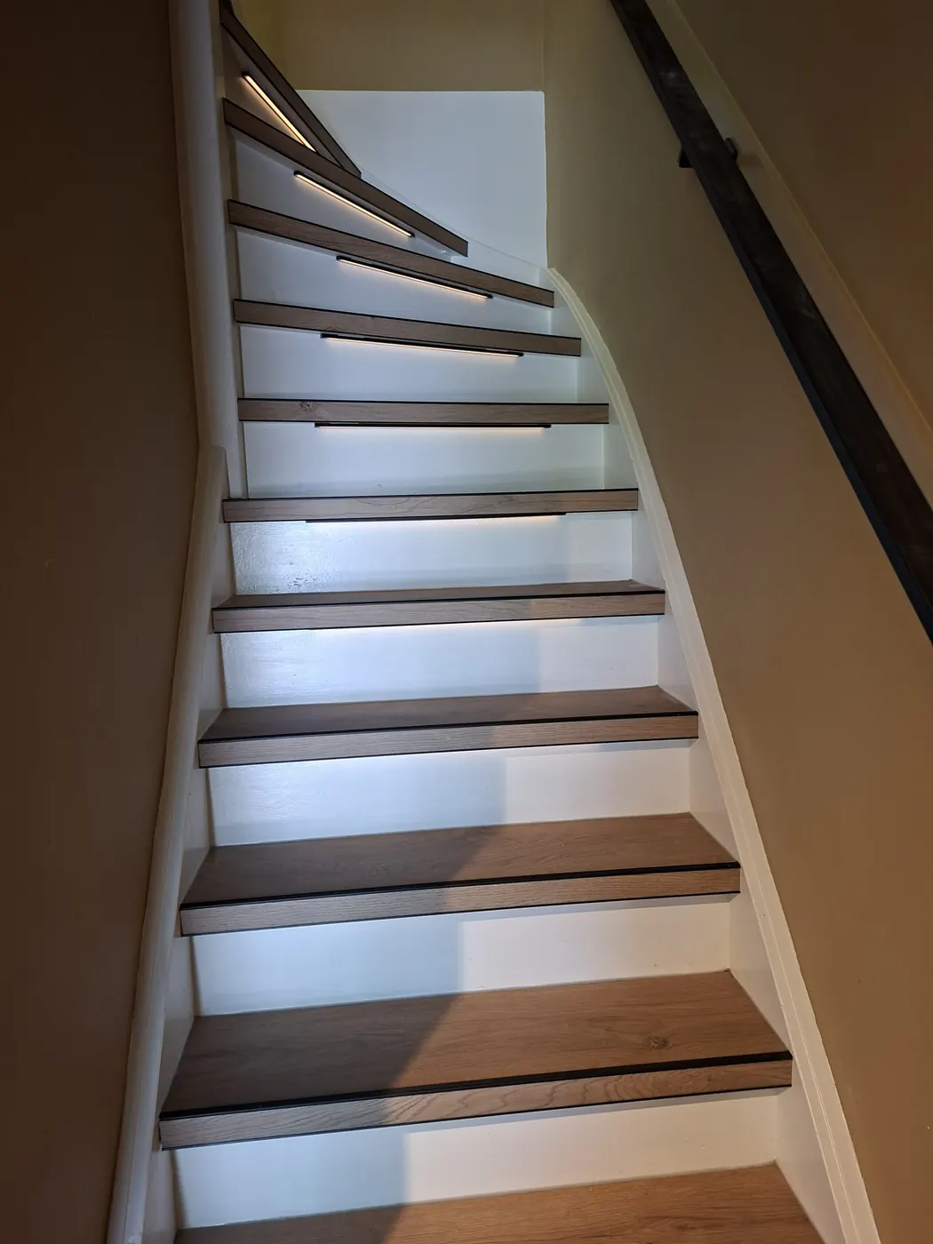 Gerenoveerde trap in Hoofddorp met houtlook overzettreden en witte stootborden